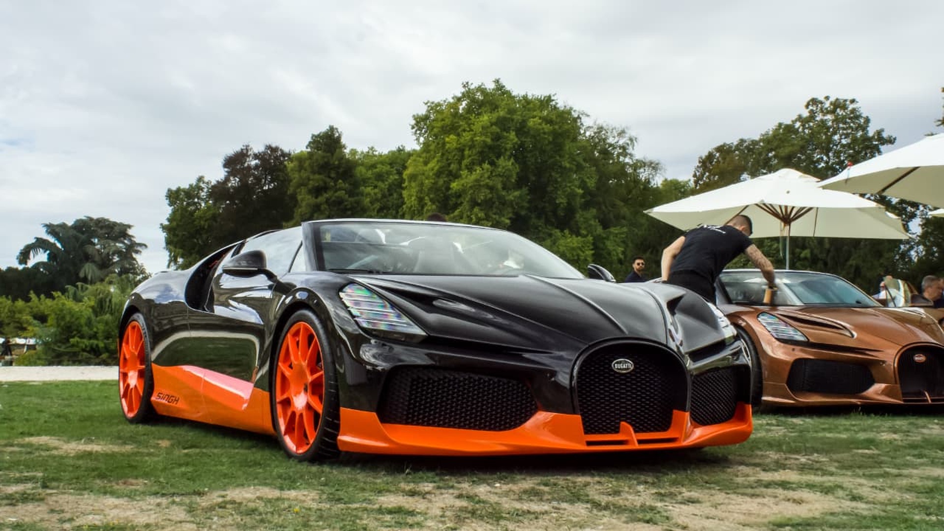 Bugatti W16 Mistral noire et orange sur la pelouse du Concours Chantilly Arts & Élégance