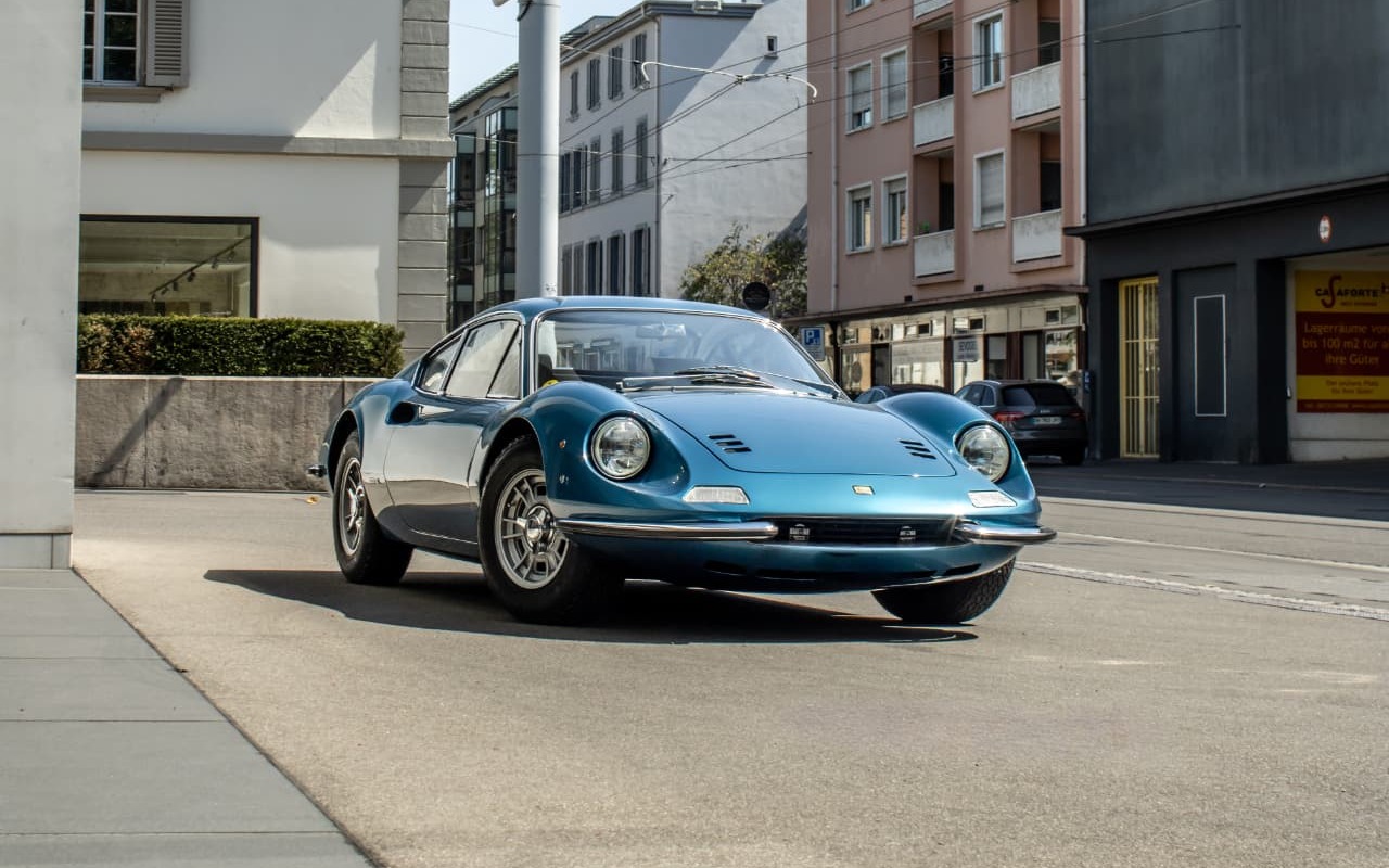 Ferrari Dino GT bleue en trois-quarts avant dans une rue de Bâle